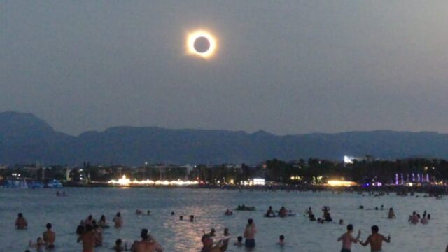 Imatge de diverses persones gaudint de l'eclipsi al mar de Salou (Ajuntament de Salou)